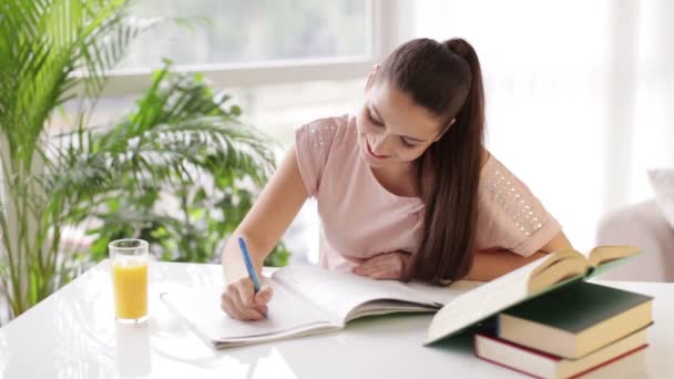 Студентська дівчина сидить за столом писати — стокове відео