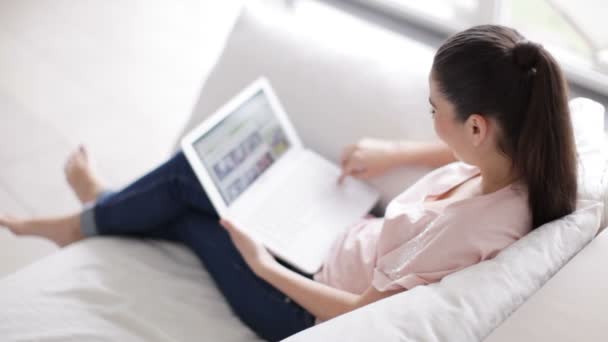 Menina sentada no sofá com laptop — Vídeo de Stock