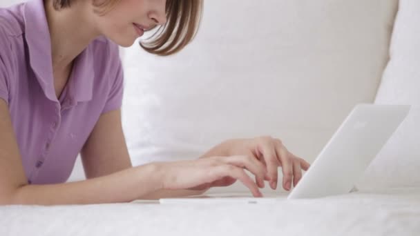 Κορίτσι χαλαρωτικό στον καναπέ, χρησιμοποιώντας φορητό υπολογιστή — Αρχείο Βίντεο