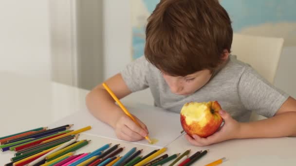 Chłopiec siedzi przy stole i rysunek — Wideo stockowe