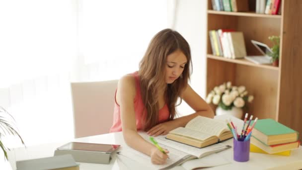 Aburrido chica sentada en escritorio escritura — Vídeo de stock