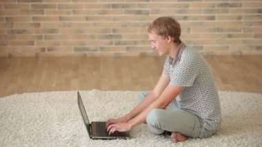 dizüstü bilgisayar kullanarak katta oturan adam