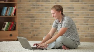 dizüstü bilgisayar kullanarak katta oturan adam