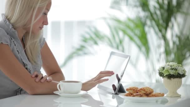 Dziewczyna siedzi w tabela przy użyciu touchpad — Wideo stockowe