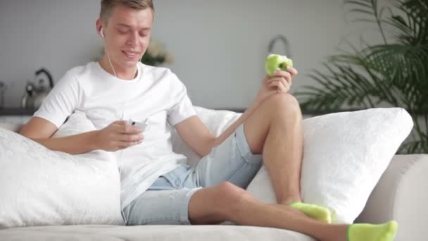 Homem relaxante no sofá com celular — Vídeo de Stock