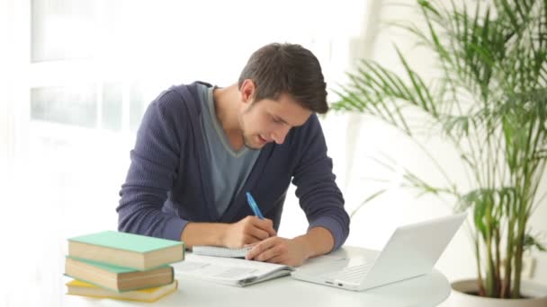 Homme assis à table étudiant — Video