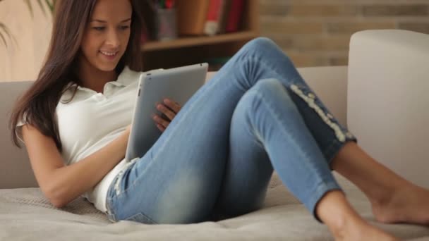 Frau entspannt auf Sofa mit Touchpad — Stockvideo