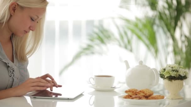 Mulher-encantadora sentada à mesa usando touchpad — Vídeo de Stock