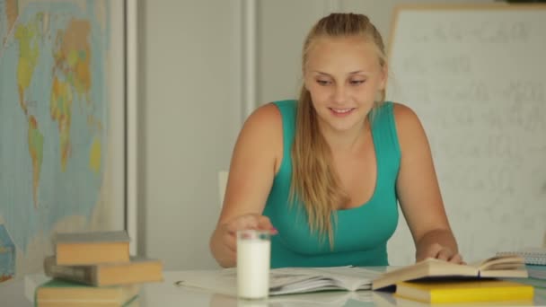 Очаровательная девушка сидит за столом — стоковое видео