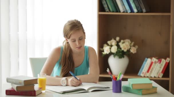 Chica sentada en escritorio escritura — Vídeos de Stock