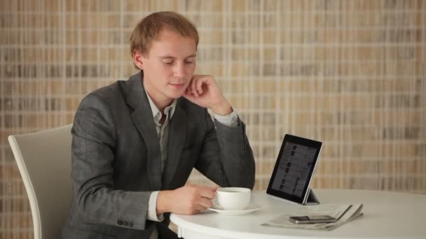 Человек, сидящий за столом с тачпадом — стоковое видео