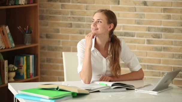 Chica bonita sentada en la mesa con libros — Vídeos de Stock