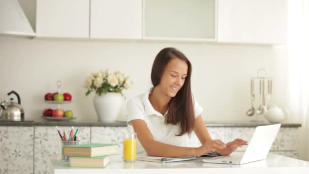 Girl sitting at table using laptop — Stock Video