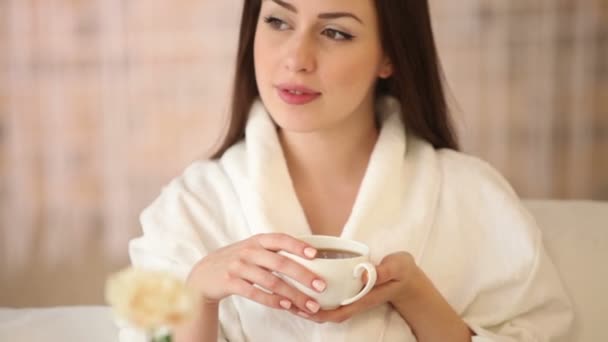 Woman sitting in bed drinking tea — Stock Video