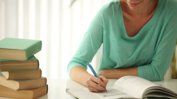 Girl sitting at desk writing — Stock Video