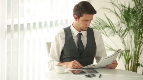 Hombre sentado a la mesa bebiendo café — Vídeos de Stock