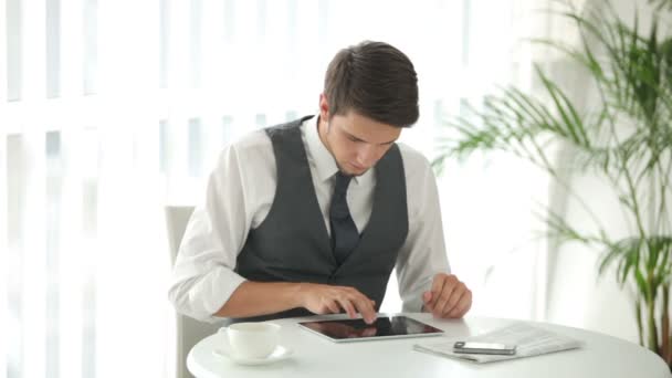 Tipo sentado en la mesa con touchpad — Vídeo de stock