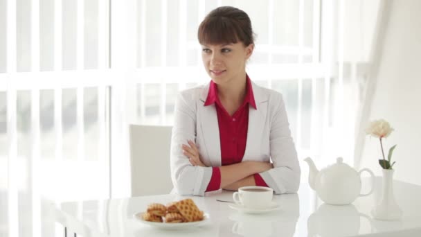 Meisje aan tafel zit met kopje thee — Stockvideo