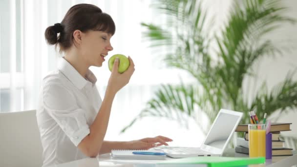 Chica sentada en la mesa usando portátil — Vídeos de Stock