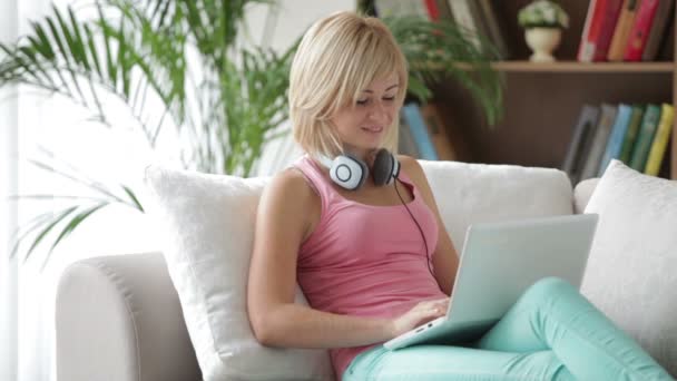 Nő a kanapé használ laptop — Stock videók