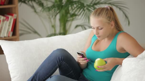 Menina relaxante no sofá usando celular — Vídeo de Stock