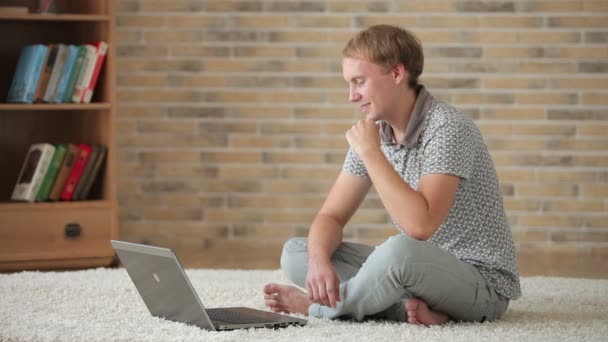 Man zit op de vloer met laptop — Stockvideo