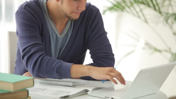 Hombre estudiando con el ordenador portátil y sonriendo — Vídeos de Stock
