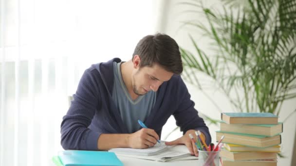 Cara sentado à mesa com livros — Vídeo de Stock