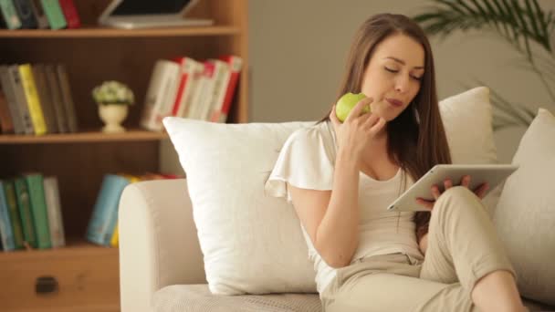 Ragazza seduta sul divano con touchpad — Video Stock