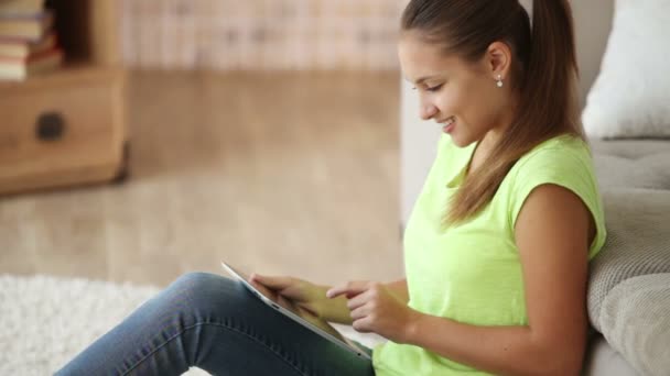 Chica sentada en el suelo usando touchpad — Vídeos de Stock