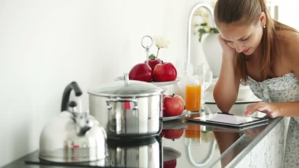 Menina de pé na cozinha usando touchpad — Vídeo de Stock