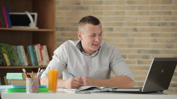 Student sitzt am Tisch und studiert — Stockvideo