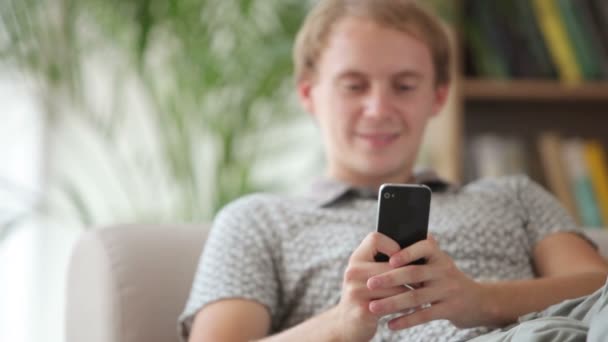 Man ontspannen met behulp van mobiele telefoon — Stockvideo