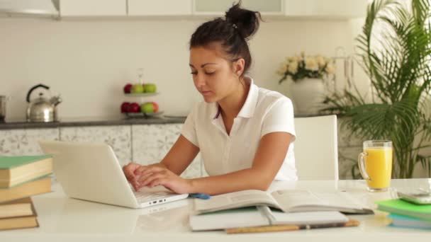 Mujer estudiando en la mesa usando portátil — Vídeos de Stock