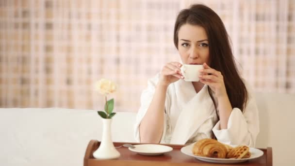 Cute girl in bathrobe sitting in bed — Stock Video