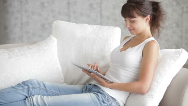 Chica sentada en el sofá usando touchpad — Vídeos de Stock