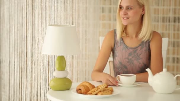 Chica sentada en la cafetería con taza de té — Vídeos de Stock