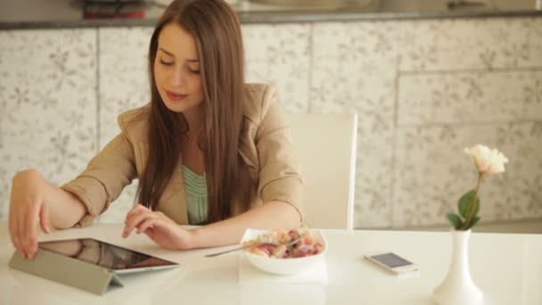 Mujer sentada en la mesa de cocina — Vídeo de stock