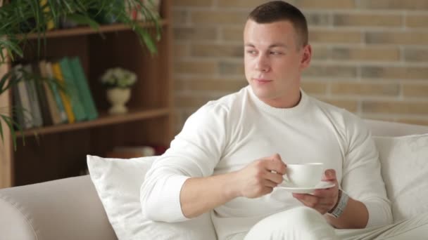 Ragazzo seduto sul divano in possesso di tazza — Video Stock