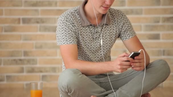 Mann trägt Kopfhörer mit Handy — Stockvideo