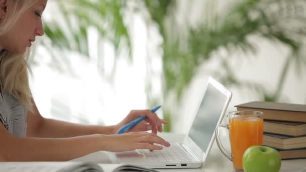 Menina sentada à mesa estudando com laptop — Vídeo de Stock