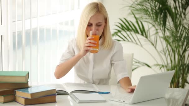 Girl sitting at table using laptop — Stock Video