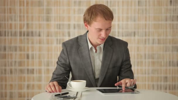 Людина сидить за столом за допомогою тачпад — стокове відео