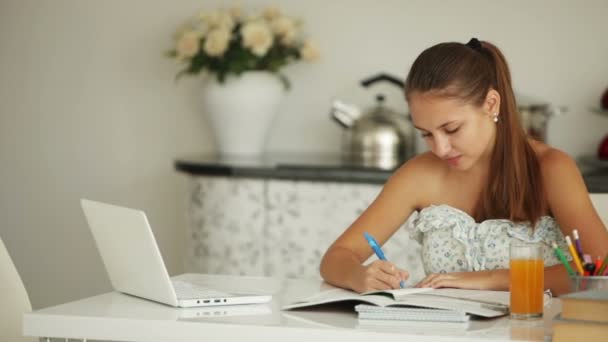 Ragazza carina seduta a tavola a studiare — Video Stock