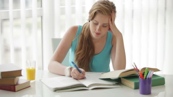 Fille assise à bureau écriture — Video