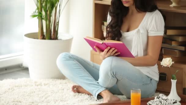 Chica sentado en piso lectura libro — Vídeos de Stock