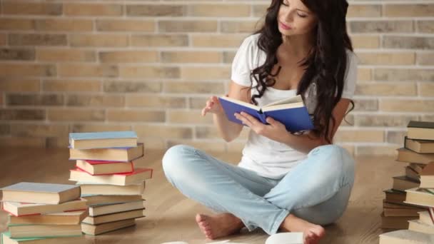 Niña sentada en el suelo leyendo — Vídeos de Stock