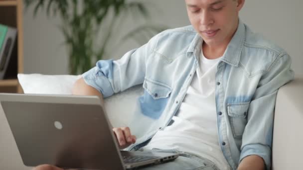 Homem relaxante no sofá com laptop — Vídeo de Stock