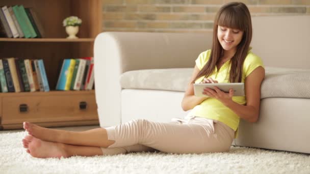 Mujer sentada en el suelo usando touchpad — Vídeos de Stock