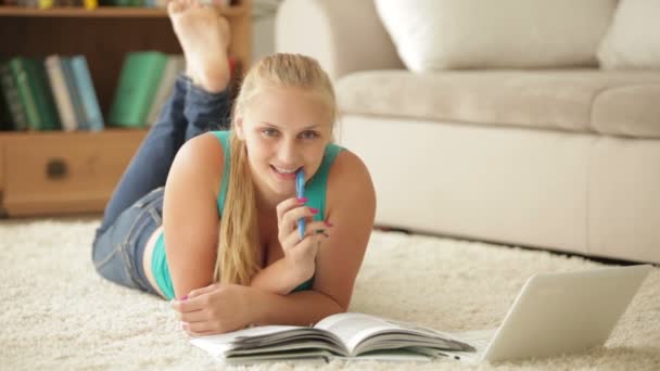 Meisje liggend op tapijt met laptop — Stockvideo